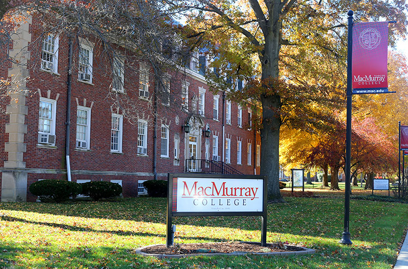 A photo of Kathryn Hall with the MacMurray College sign out front.