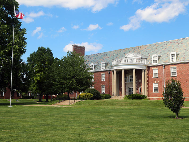 A photo of Rutledge Hall and the flag pole in the front lawn.