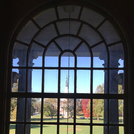 A photo showing Annie Merner Chapel as seen through one of the windows of Henry Pfeiffer Library.